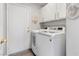 This laundry room features overhead cabinets, washer and dryer, and a door to the outside for convenience at 3157 Capetown Way, Las Vegas, NV 89128