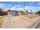 Single-story home with a long driveway and fenced front yard under a sunny, blue sky at 3200 E Owens Ave, North Las Vegas, NV 89030