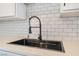 Close-up of a modern kitchen sink with stylish fixtures and subway tile backsplash at 3200 E Owens Ave, North Las Vegas, NV 89030
