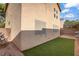 This backyard has artificial turf, a brick wall and a view of the rear exterior of the home at 3205 Rainmaker St, Las Vegas, NV 89129