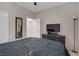 This bedroom features neutral walls, closet, and dark dresser beneath a flatscreen television at 3205 Rainmaker St, Las Vegas, NV 89129
