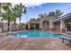 View of the community pool surrounded by lounge chairs, cabana and tall palm trees at 3205 Rainmaker St, Las Vegas, NV 89129