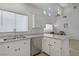 Open kitchen view with white cabinets, a stainless steel dishwasher, and bright natural light at 3205 Rainmaker St, Las Vegas, NV 89129