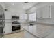 Well-lit kitchen with stainless steel appliances, white cabinets, and granite countertops at 3205 Rainmaker St, Las Vegas, NV 89129