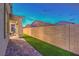 Spacious backyard featuring a brick fence, artificial grass, and paved patio at 326 Beethoven Ridge Dr, Henderson, NV 89011
