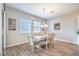 Well-lit dining area with modern chandelier and wood-look floors next to the kitchen at 326 Beethoven Ridge Dr, Henderson, NV 89011