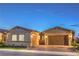 Charming single-story home featuring a two-car garage, desert landscaping, and a welcoming facade during twilight hours at 326 Beethoven Ridge Dr, Henderson, NV 89011