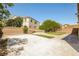 Private backyard features a concrete patio, mature trees, and a charming brick wall, offering a serene outdoor space at 3820 Alpine Track Ave, North Las Vegas, NV 89032