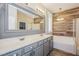 Bathroom with a double sink vanity, large framed mirror, and soaking tub with decorative tiling at 3820 Alpine Track Ave, North Las Vegas, NV 89032