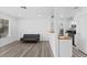Bright living room with a modern sofa, wood-look flooring, and an open kitchen view at 3923 Gogo Way # 106, Las Vegas, NV 89103