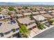 An aerial view shows a vast neighborhood with tile roofs, solar panels, and scenic mountain views at 4212 Juanita May Ave, North Las Vegas, NV 89032