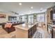 This kitchen flows into the living room with dark cabinetry, island seating and tile floor at 4212 Juanita May Ave, North Las Vegas, NV 89032