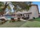 Relaxing backyard with a pool, sun loungers, and outdoor seating under a large shady tree at 4330 Flandes St, Las Vegas, NV 89121