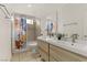 Bright bathroom featuring a double sink vanity, patterned shower curtain, and tiled shower at 4330 Flandes St, Las Vegas, NV 89121