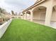 Backyard featuring an outdoor patio space with artificial grass and a well maintained stucco perimeter fence at 5040 Jacarilla Ln, North Las Vegas, NV 89031