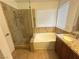 Bathroom featuring a tub, shower with glass door, and vanity with granite countertop at 5040 Jacarilla Ln, North Las Vegas, NV 89031