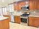 Well-equipped kitchen with stainless steel appliances, granite countertops, and classic wood cabinets at 5040 Jacarilla Ln, North Las Vegas, NV 89031