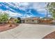 Charming single-story home with a large driveway, carport, and desert landscaping in front yard at 5203 Treasure Ave, Las Vegas, NV 89122