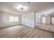 Bright, open living room with wood-look floors and modern lighting, adjacent to an updated kitchen at 5203 Treasure Ave, Las Vegas, NV 89122