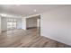 An open-concept living room featuring wood-look flooring and sliding glass doors to the patio at 5203 Treasure Ave, Las Vegas, NV 89122