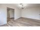 A spacious main bedroom with wood-look floors, modern lighting, and a walk-in closet at 5203 Treasure Ave, Las Vegas, NV 89122