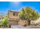 Charming two-story home featuring a two-car garage, desert landscaping, and a shade tree at 5232 Pendergrass St, North Las Vegas, NV 89081