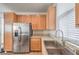 Kitchen featuring stainless steel refrigerator, wood cabinets, and granite countertops at 5232 Pendergrass St, North Las Vegas, NV 89081