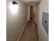 Hallway with neutral paint, tile floors, and a view to rooms beyond at 5710 E Tropicana Ave # 1172, Las Vegas, NV 89122