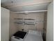 A well-lit laundry room featuring a washer, dryer, and wire rack shelving at 5710 E Tropicana Ave # 1172, Las Vegas, NV 89122