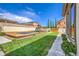 Spacious backyard offers a manicured lawn, a playground, and a built-in trampoline for outdoor fun at 5855 Boulder Brook Ct, Las Vegas, NV 89149