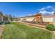 A vibrant backyard with green grass, a play structure, and a pool area that make the space a perfect Gathering retreat at 5855 Boulder Brook Ct, Las Vegas, NV 89149
