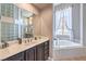 Elegant bathroom with a soaking tub and large vanity, featuring unique glass block accents and plenty of natural light at 5855 Boulder Brook Ct, Las Vegas, NV 89149
