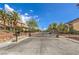 A gated entrance to a community featuring lush desert landscaping and multi-story homes beneath a bright blue sky at 5855 Boulder Brook Ct, Las Vegas, NV 89149