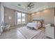 Bright main bedroom featuring tray ceilings, a ceiling fan, and a large window for natural light at 5855 Boulder Brook Ct, Las Vegas, NV 89149