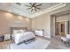 Comfortable main bedroom with tray ceiling, ceiling fan and seating area at 5855 Boulder Brook Ct, Las Vegas, NV 89149