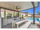 Covered outdoor kitchen with grill, dining table, and view of the sparkling pool at 5855 Boulder Brook Ct, Las Vegas, NV 89149