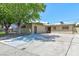 Home exterior shot shows long driveway and low maintenance landscape with mature trees at 6320 Shawnee Ave, Las Vegas, NV 89107