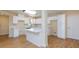 Bright kitchen features white cabinets, island with breakfast bar, and updated appliances at 6320 Shawnee Ave, Las Vegas, NV 89107