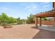 Large backyard featuring gravel landscaping, a fire pit, mature trees, and a covered patio at 6480 Chebec St, North Las Vegas, NV 89084