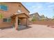 Spacious backyard with neutral gravel, covered patio, and block wall at 6480 Chebec St, North Las Vegas, NV 89084
