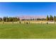 A sunny day at the driving range, golfers enjoying a day on the lush green field with mountains in the distance at 6480 Chebec St, North Las Vegas, NV 89084