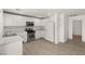 Bright kitchen with white cabinets, stainless steel appliances, and wood-look tile flooring at 6480 Chebec St, North Las Vegas, NV 89084