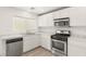 Well-lit kitchen with stainless steel appliances, white cabinets, and light countertops at 6480 Chebec St, North Las Vegas, NV 89084
