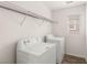 Bright laundry room featuring modern washer and dryer, wire rack shelving, and window at 6480 Chebec St, North Las Vegas, NV 89084