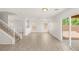 Bright living room featuring modern wood-look tile flooring, staircase, and backyard access at 6480 Chebec St, North Las Vegas, NV 89084