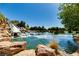 Picturesque pond featuring rocks and cascading waterfall amidst lush landscaping, creating a serene and natural community setting at 6480 Chebec St, North Las Vegas, NV 89084