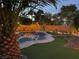 Relaxing backyard featuring a pool, palm trees, artificial grass, and patio furniture under a twilight sky at 6756 Sea Swallow St, North Las Vegas, NV 89084