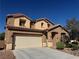 Charming two-story home features a two car garage and landscaped front yard under a clear blue sky at 6756 Sea Swallow St, North Las Vegas, NV 89084