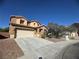 Charming two-story home features a two car garage and landscaped front yard under a clear blue sky at 6756 Sea Swallow St, North Las Vegas, NV 89084
