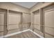 Empty walk-in closet with carpeted floors and wooden rods for ample storage of clothes, shoes and other belongings at 7029 Bocaire Dr, Las Vegas, NV 89131